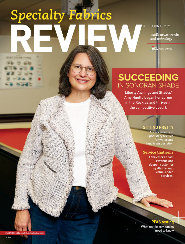 Front cover of "Specialty Fabrics REVIEW" features a woman with glasses, wearing a light woven jacket, against a red backdrop. Text highlights industry topics.