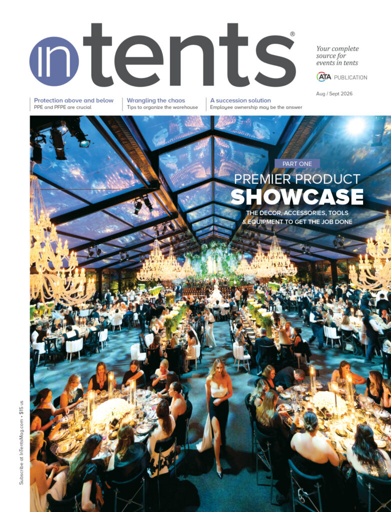 Elegant indoor event under a large tent, featuring beautifully arranged tables, vibrant decorations, and guests enjoying the atmosphere.